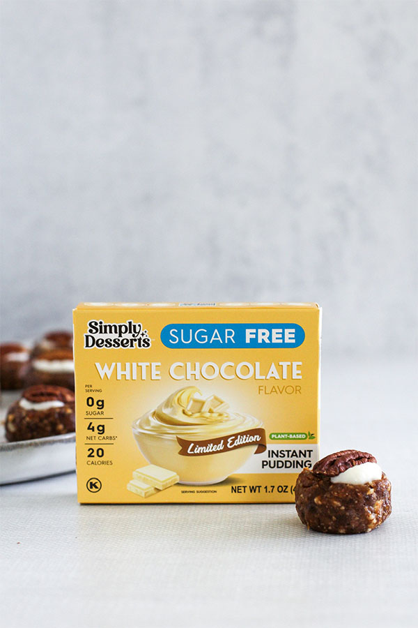 A box of Simply Desserts Sugar-Free White Chocolate Pudding with a White Chocolate Toffee Truffle placed beside it, showcasing the key ingredient in the recipe