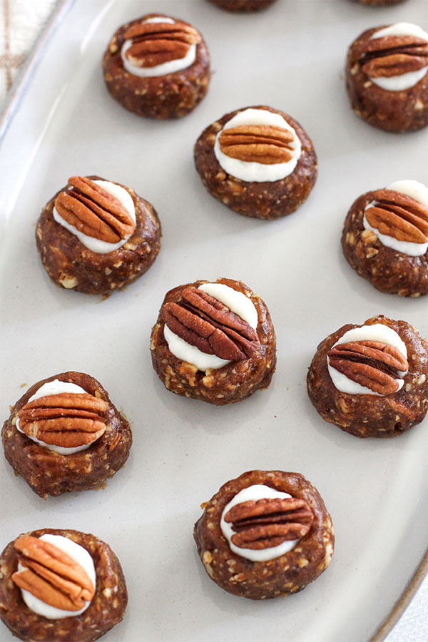 A top-down view of multiple White Chocolate Toffee Truffles, emphasizing their uniform shape and decorative pecan topping