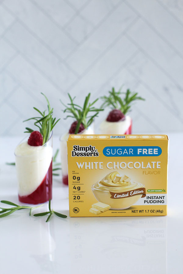 Simply Desserts Sugar Free White Chocolate Pudding box displayed with white chocolate cranberry passionfruit shooters in the background