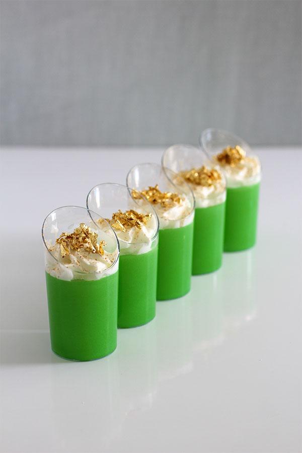Irish Jel Shots - Green Irish Jello shots with whipped cream and gold flakes in slanted cups