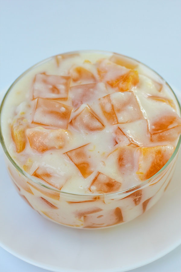 Top-down view of peaches and cream jel salad showing peach jel cubes and pudding