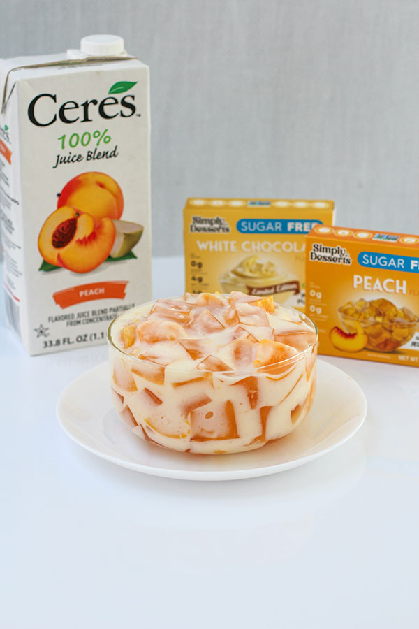 Peaches and cream jel salad surrounded by Ceres Peach Juice and Simply Desserts product boxes