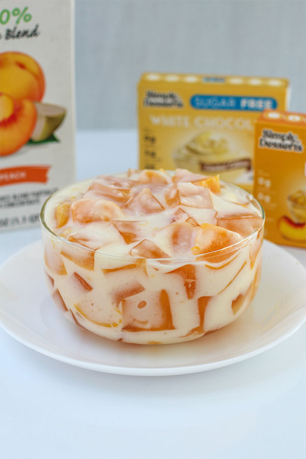 Close-up of peaches and cream jel salad with dessert mix packaging in the background