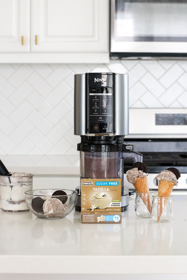 Cookies and cream pudding ice cream cones in glass jars with Simply Desserts vanilla pudding box and Ninja Creami in a white kitchen