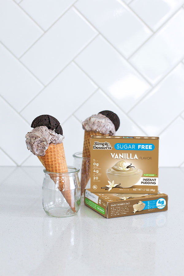Vanilla pudding mix box with two ice cream cones in jars behind it on a white kitchen counter