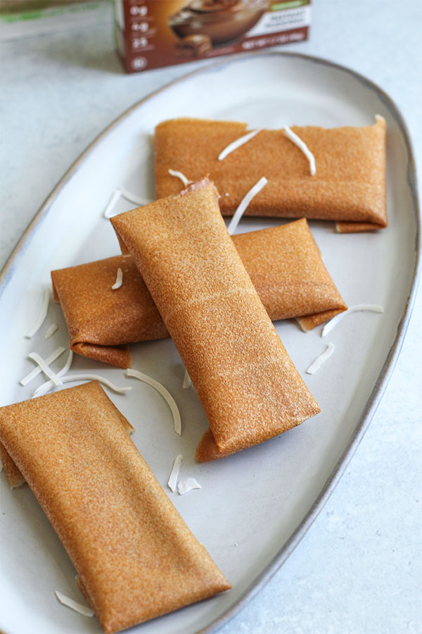 Four folded coconut wraps filled with chocolate pudding ice cream, topped with shredded coconut