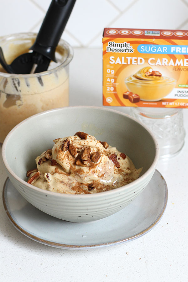 Bowl of salted caramel apple pecan crunch ice cream next to Simply Desserts sugar free salted caramel pudding mix