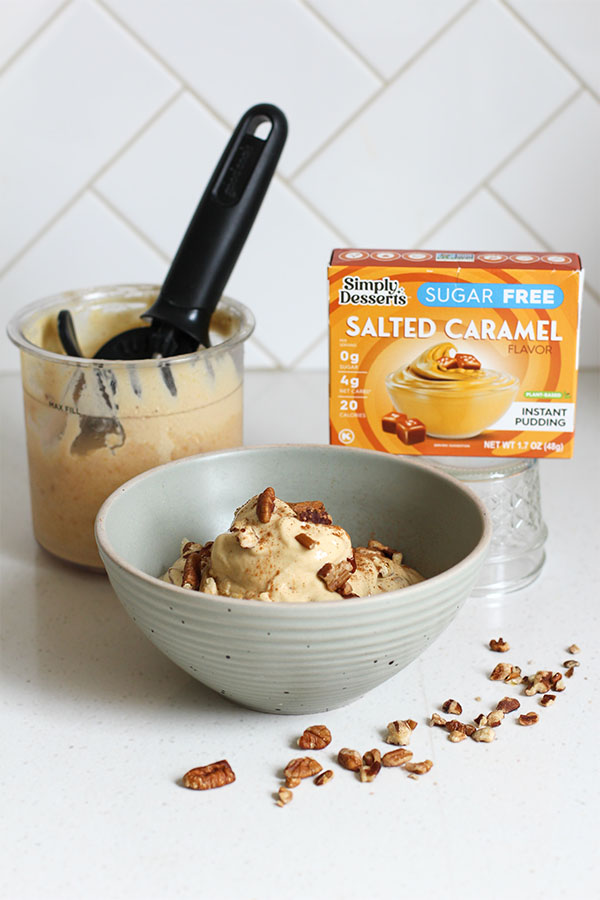 Salted caramel apple pecan crunch ice cream with chopped pecans scattered on countertop