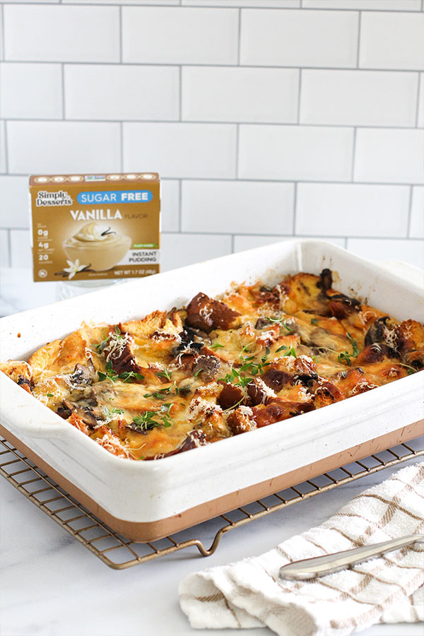 Baked savory bread pudding with mushrooms and cheese next to Simply Desserts sugar-free vanilla pudding box
