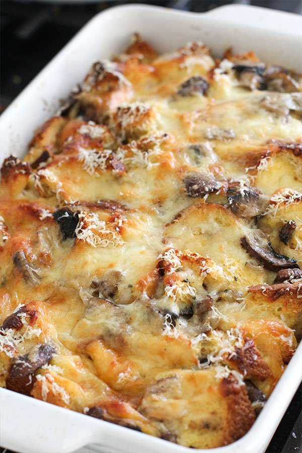 Close-up of golden baked savory bread pudding with mushrooms and melted cheese