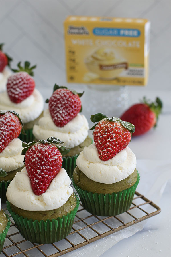 Freshly baked matcha cupcakes cooling on a wire rack before frosting