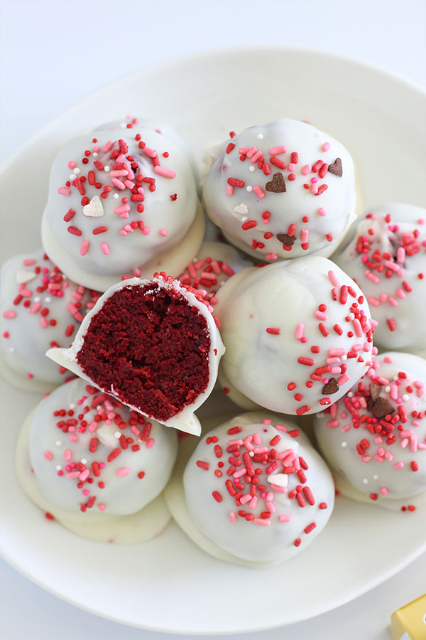 Red velvet cake pop cut open showing soft red velvet centre and white chocolate shell