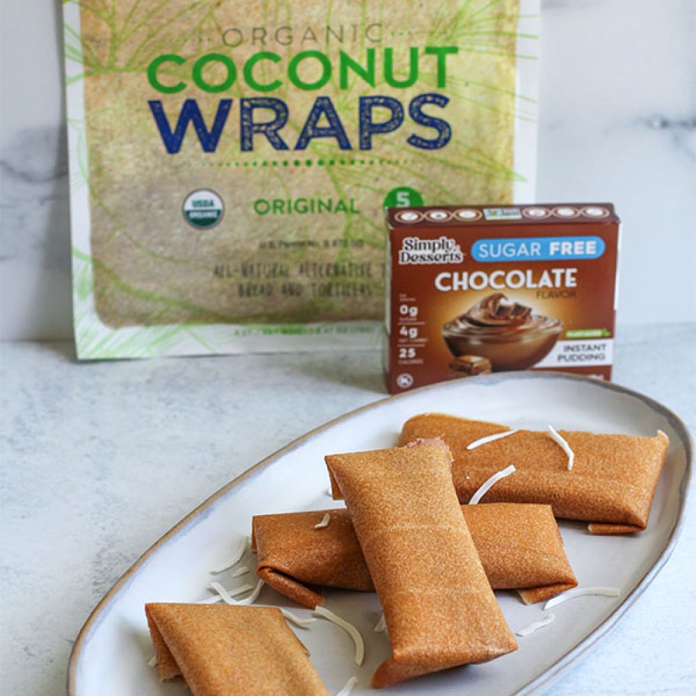 Plate of chocolate coconut ice cream wraps in front of Nuco Coconut Wraps and Simply Dessert Chocolate Pudding packaging