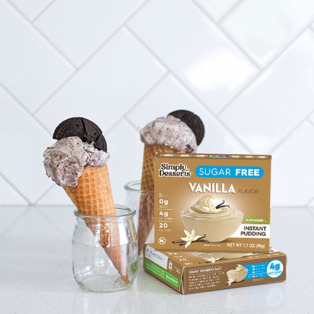 Vanilla pudding mix box with two ice cream cones in jars behind it on a white kitchen counter